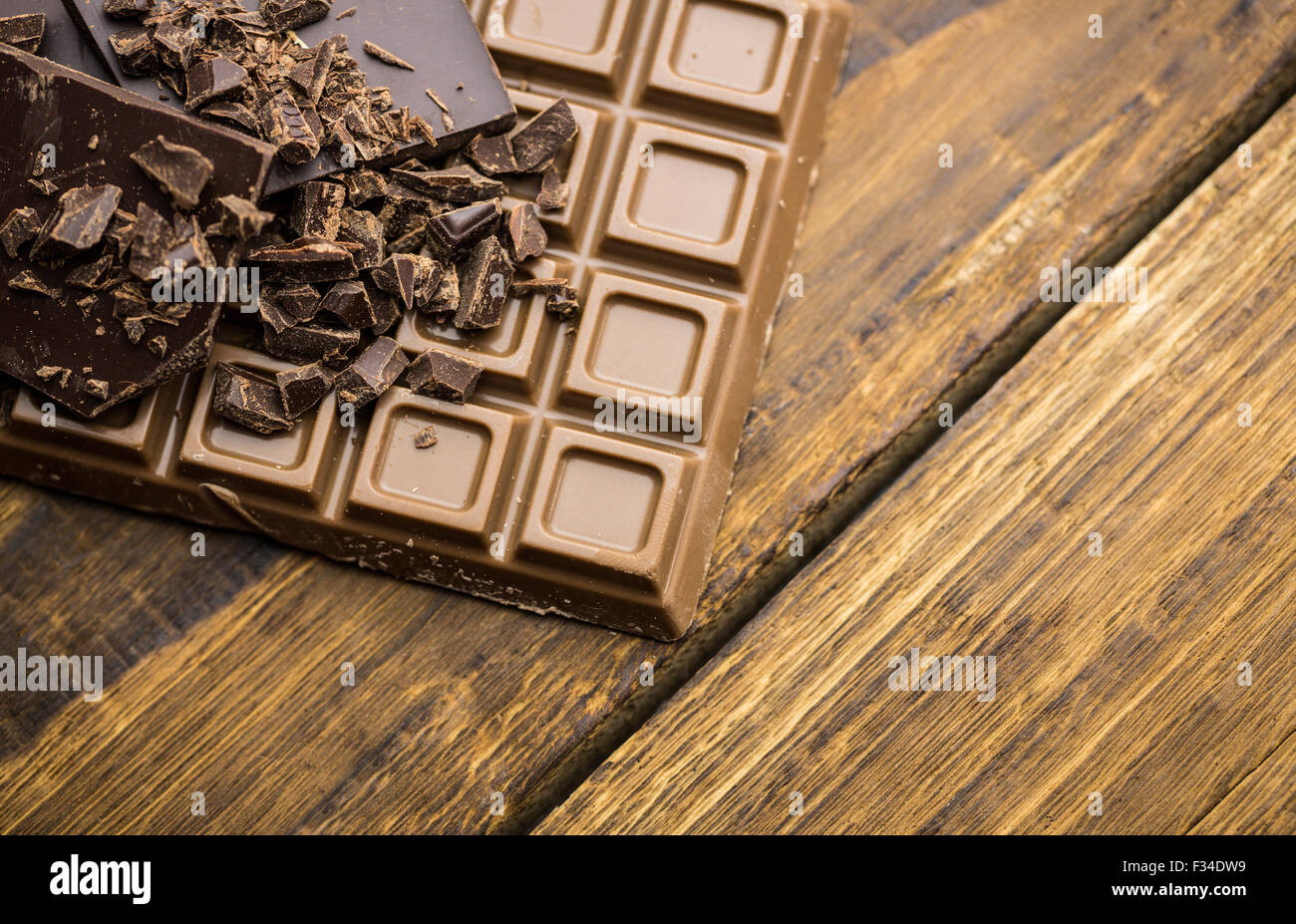 Cioccolato fondente e al latte su un tavolo di legno Foto Stock