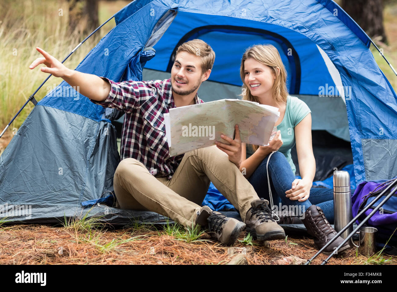 Giovani piuttosto escursionista giovane seduto in una tenda puntando Foto Stock