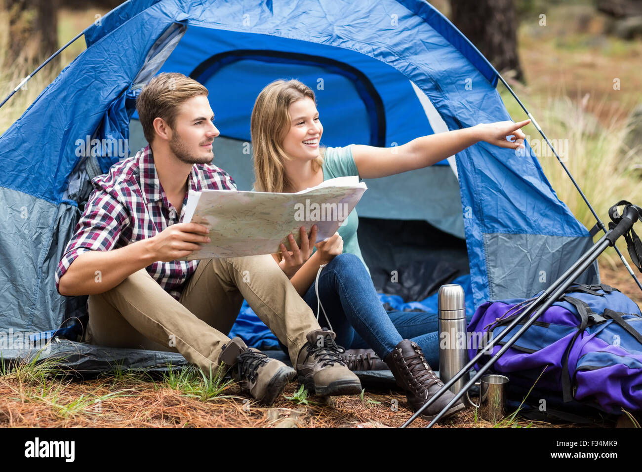 Giovani piuttosto escursionista giovane seduto in una tenda puntando Foto Stock