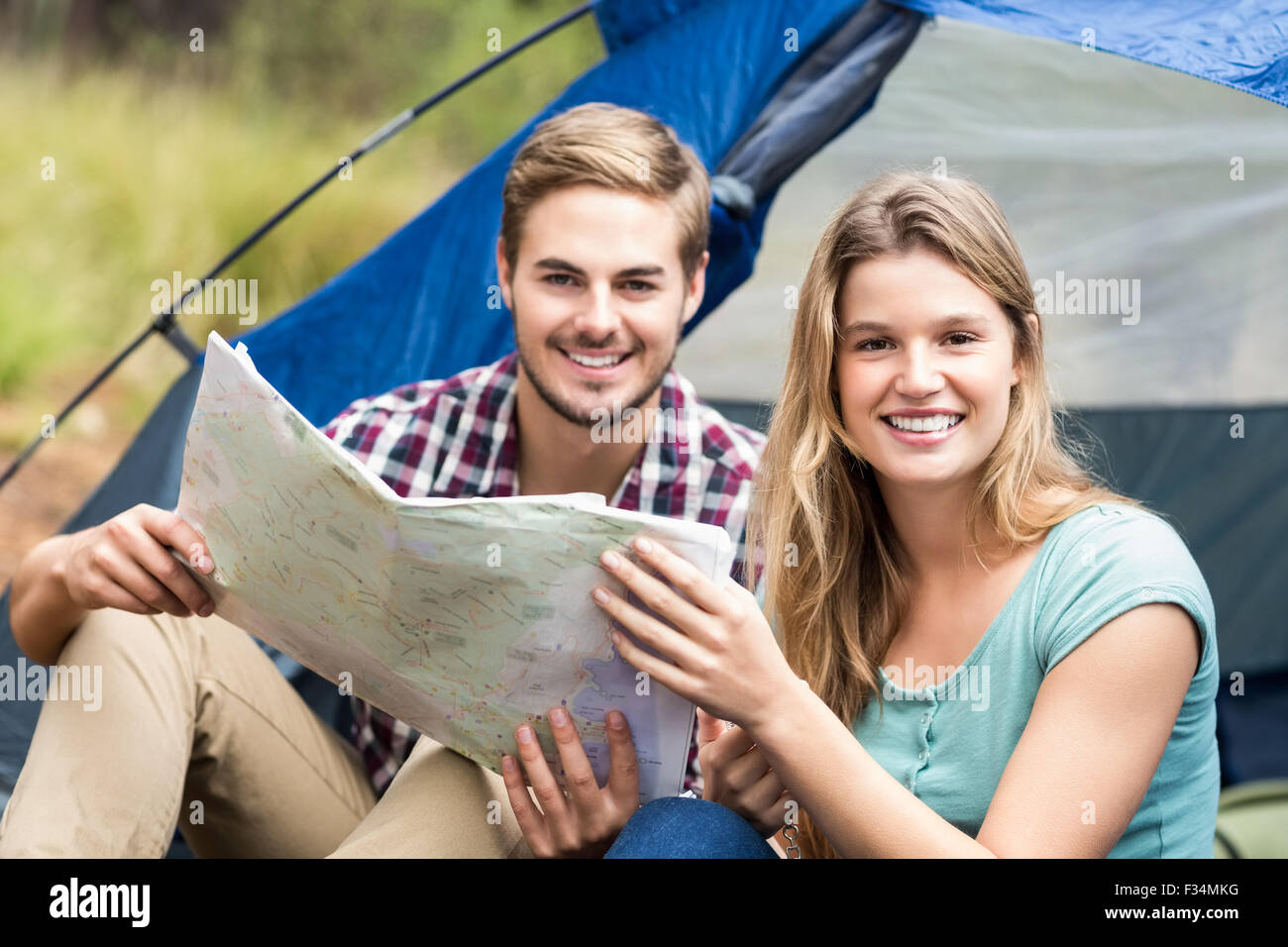 Giovani piuttosto escursionista giovane seduto in una tenda guardando la fotocamera Foto Stock