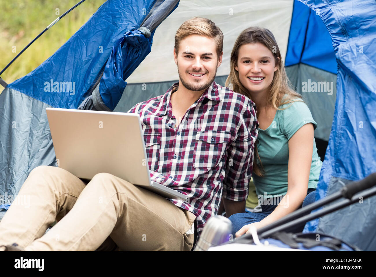 Giovani piuttosto escursionista giovane seduto in una tenda guardando la fotocamera Foto Stock