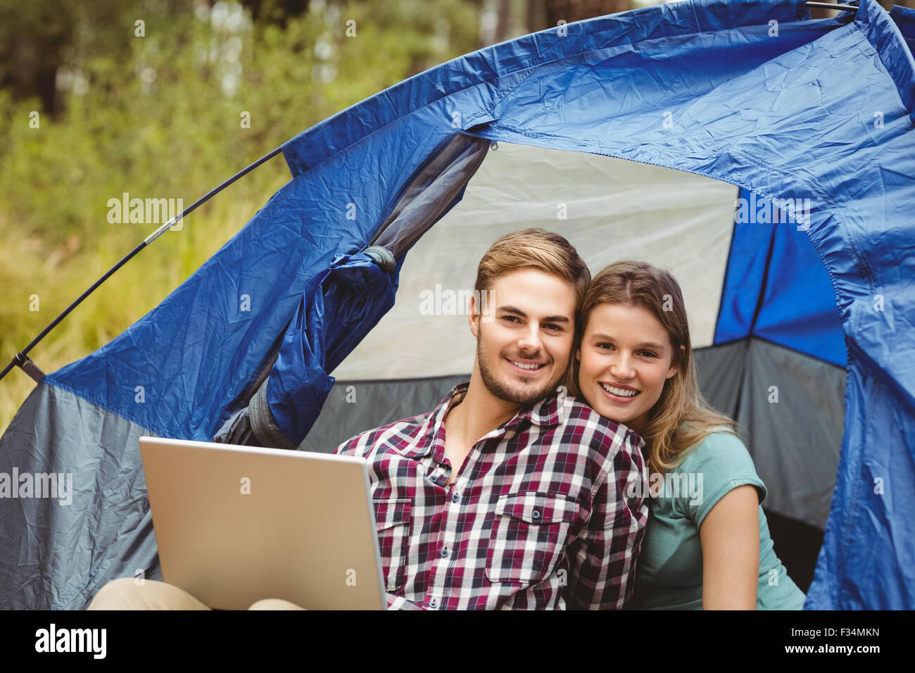 Giovani piuttosto escursionista giovane seduto in una tenda guardando la fotocamera Foto Stock