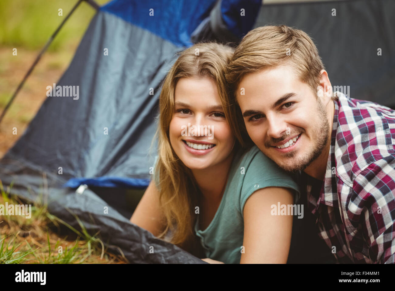Ritratto di una giovane coppia felice giacente in una tenda Foto Stock
