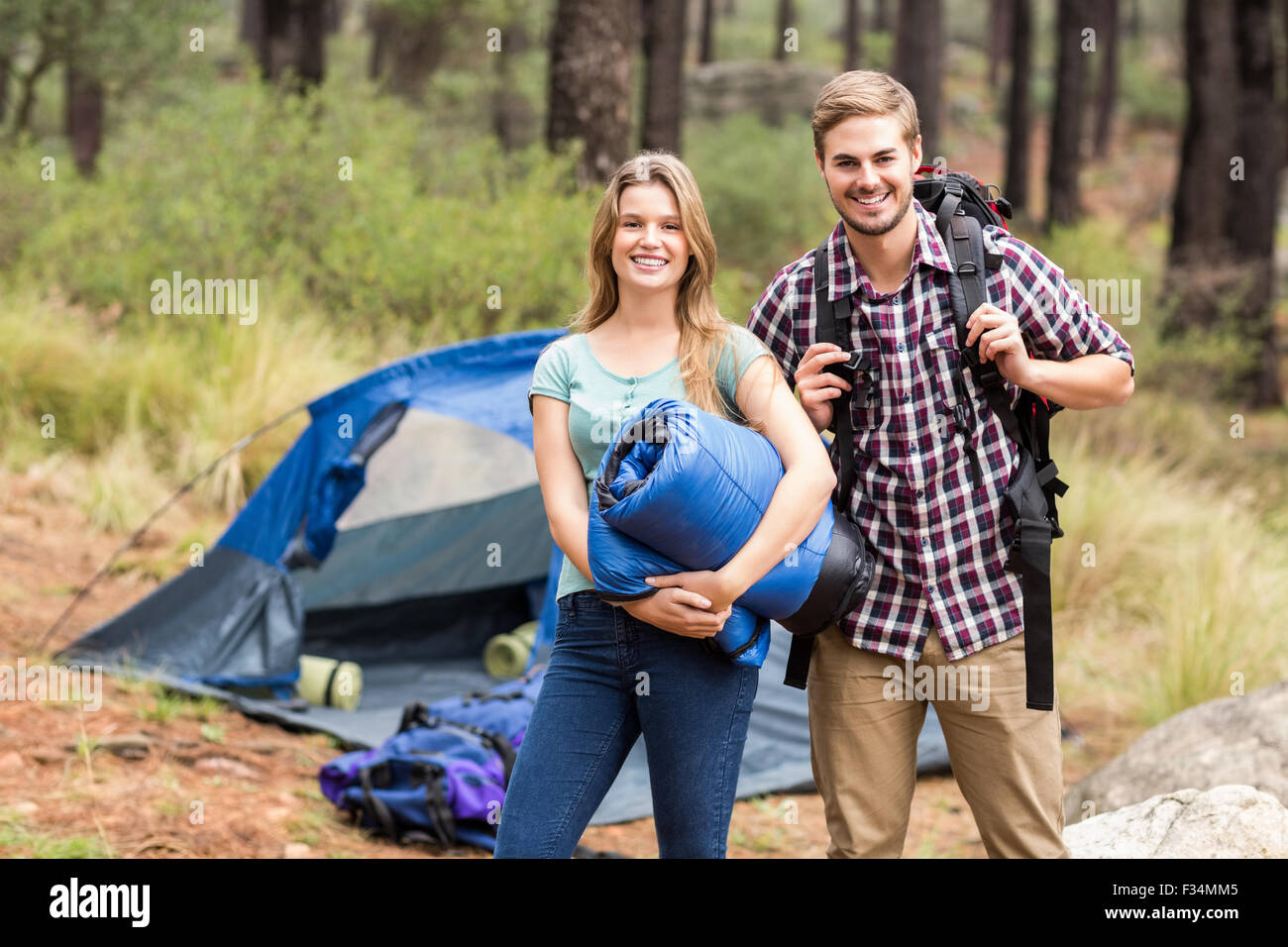 Ritratto di un giovane piuttosto escursionista giovane tenendo un sacco a pelo e zaino Foto Stock