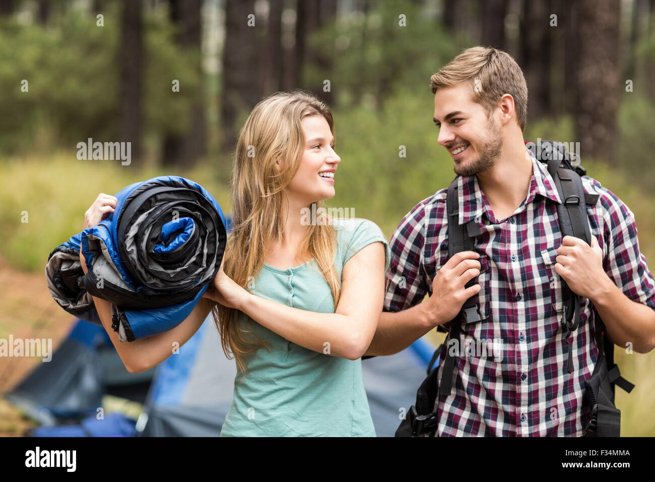 Giovani piuttosto escursionista giovane tenendo un sacco a pelo e zaino Foto Stock