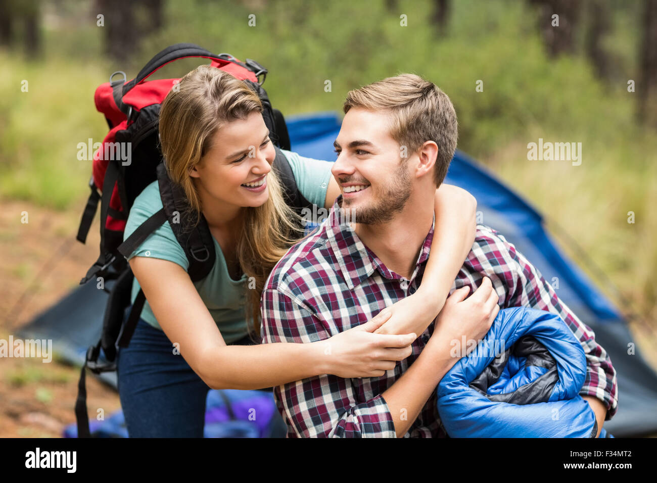 Giovani piuttosto escursionista giovane tenendo un sacco a pelo e zaino Foto Stock