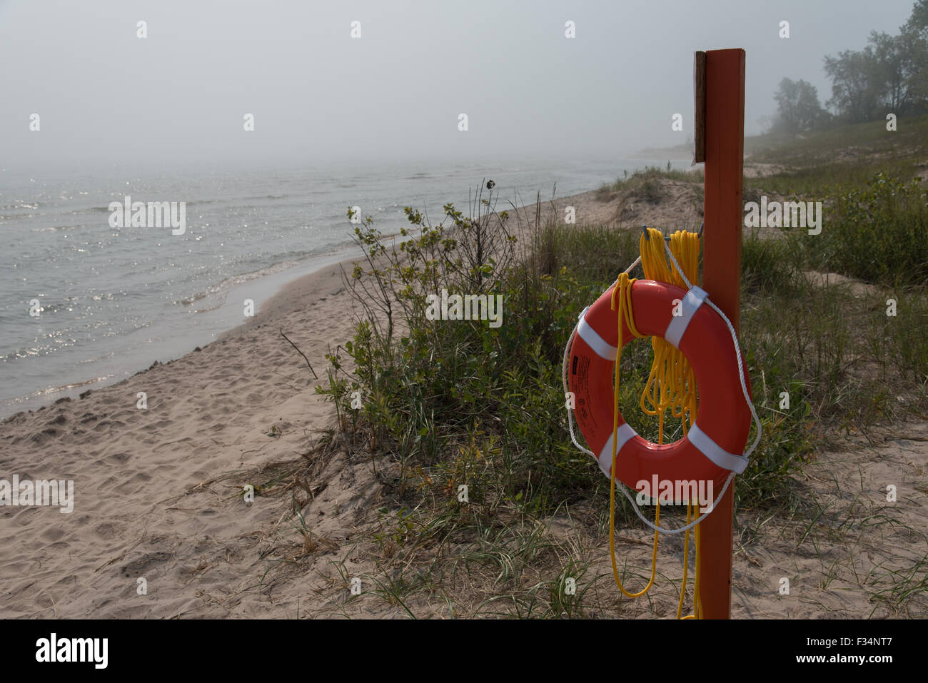 Un anello di vita si siede su un post sulla spiaggia pronti a salvare i bagnanti da annegamento. Guarda le acque del lago Michigan coperti in Foto Stock