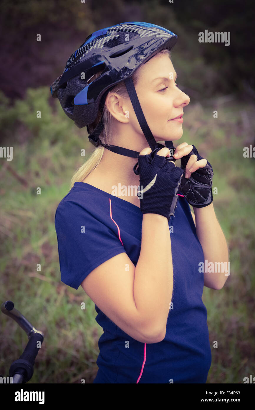 Athletic bionda mettendo sul casco Foto Stock