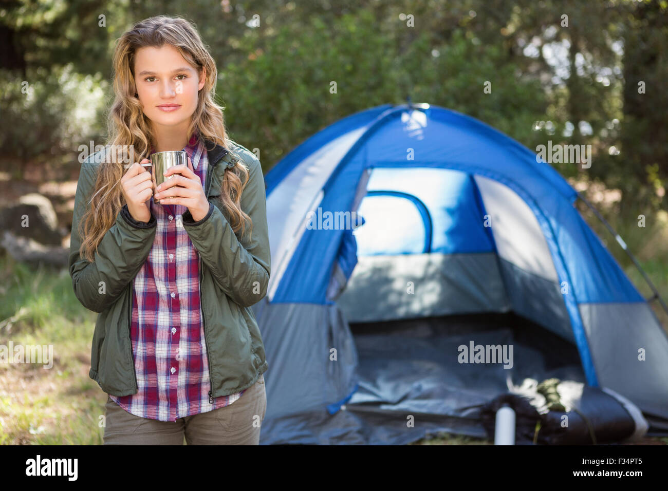 Bella bionda camper in piedi nella parte anteriore della tenda Foto Stock