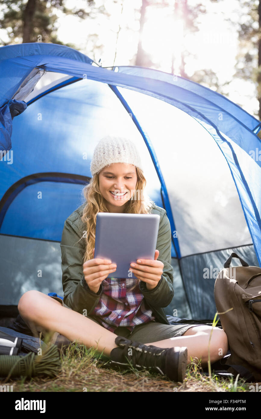 Bella bionda camper utilizzando tablet e seduta in tenda Foto Stock
