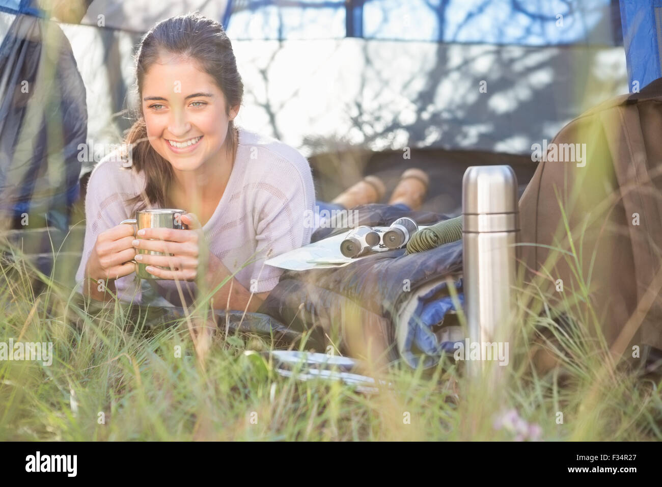 Sorridente brunette camper giacente in tenda Foto Stock