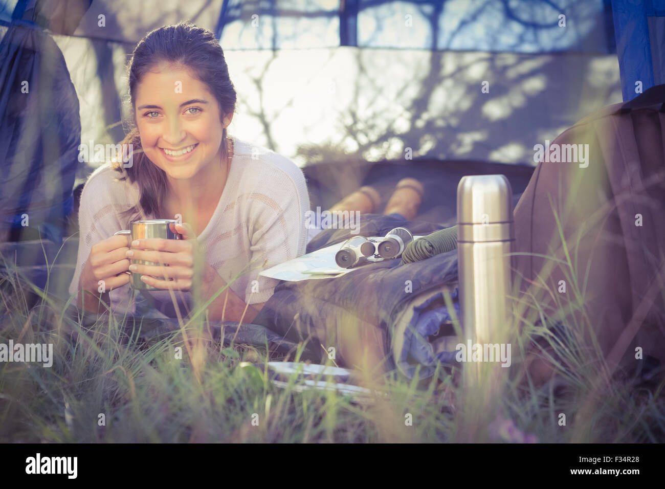Sorridente brunette camper giacente in tenda Foto Stock