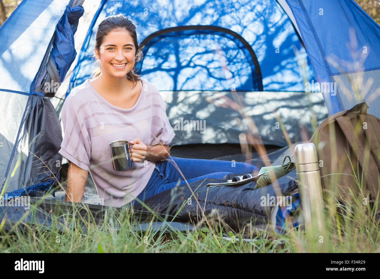Sorridente brunette camper seduto in tenda Foto Stock