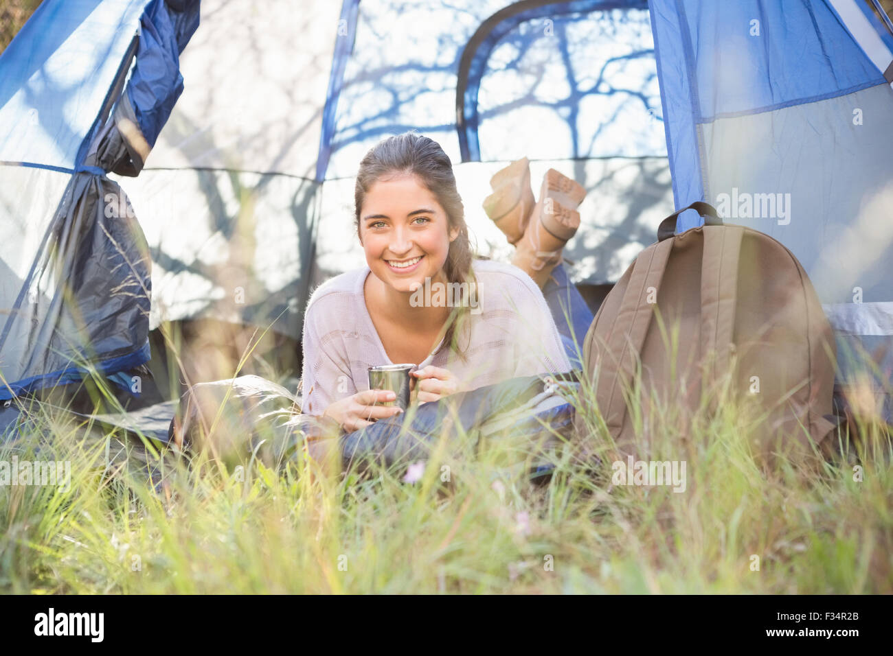 Sorridente brunette camper giacente in tenda Foto Stock