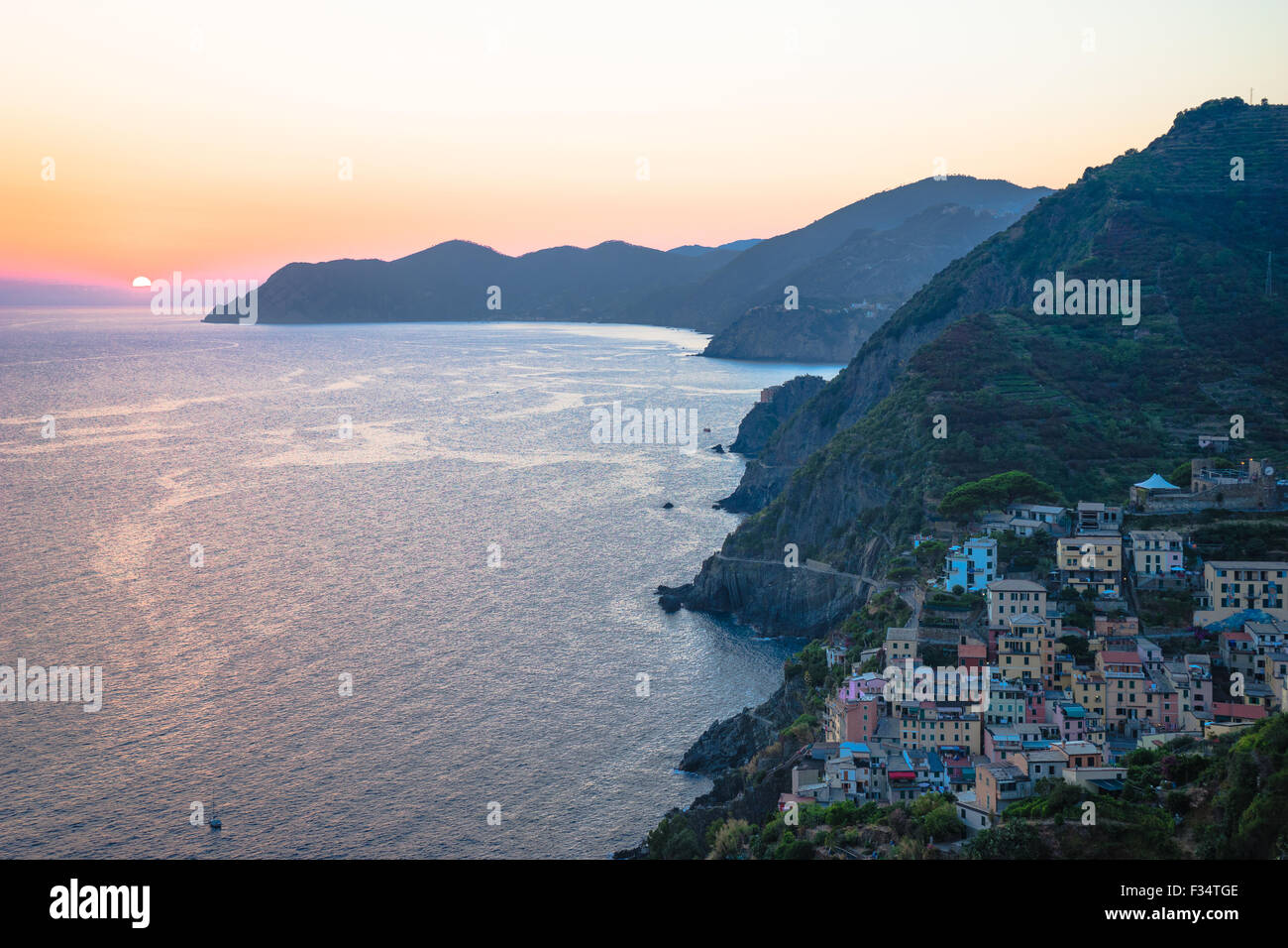 Il sole tramonta su Riomaggiore, la prima fermata e forse la più bella vista dell'Italia Cinque Terre. Foto Stock