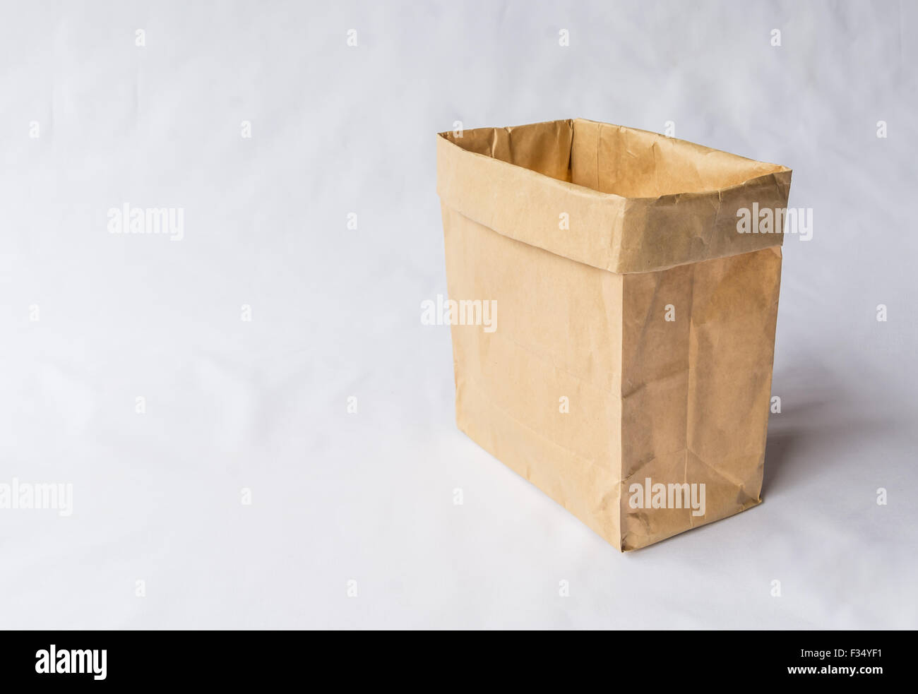 Un sacchetto di carta supporto verticale su sfondo grigio per il riutilizzo shopping bag Foto Stock