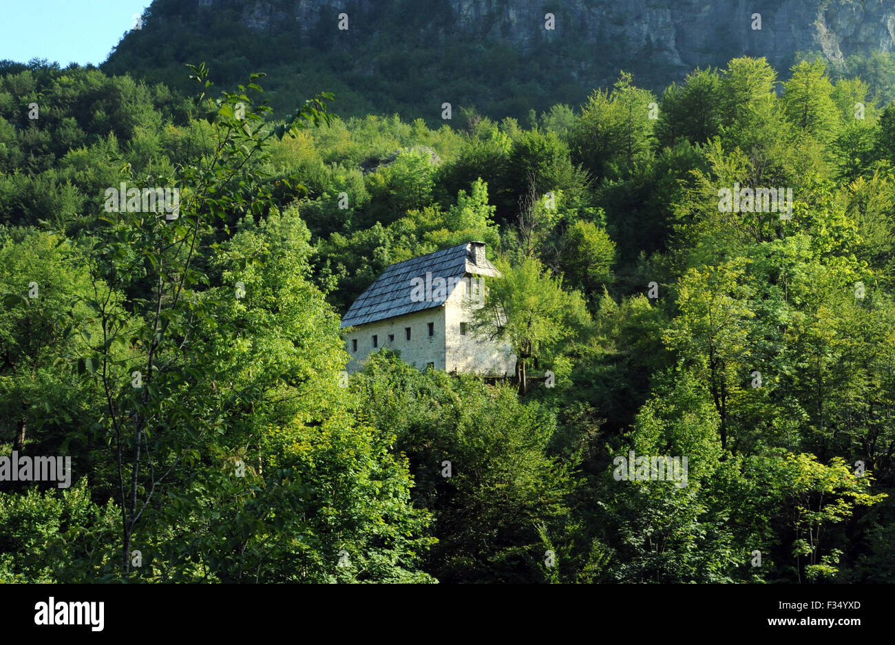 Casale in pietra con un tetto incastrata sopra l'occhio azzurro di Kapre, Syri i Kalter ho Kaprese, un fiume azzurro piscina. Teth, Tethi, Albania. Foto Stock