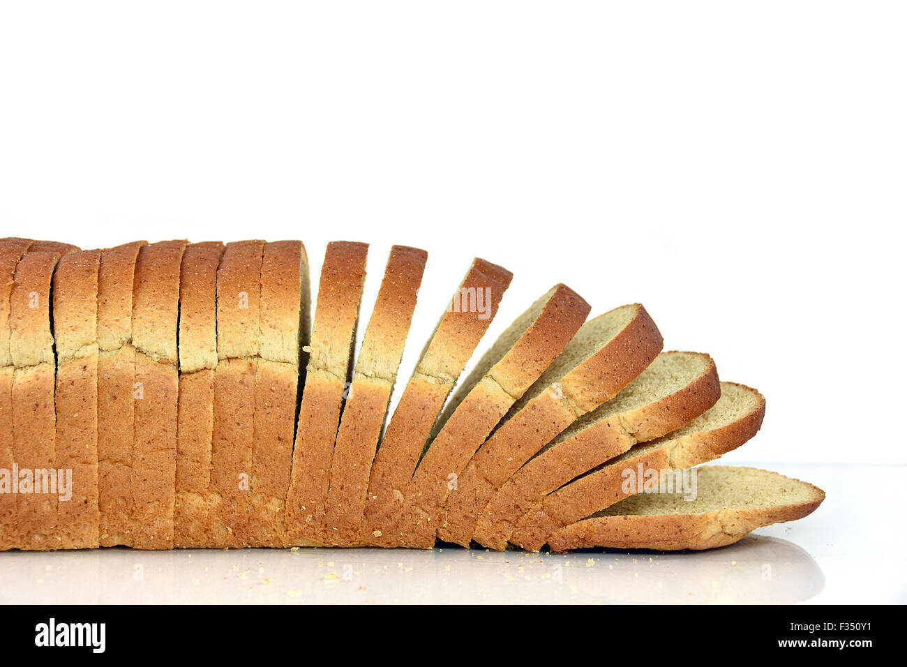 Fette di pane integrale sul bianco lucido superficie e sfondo bianco. Foto Stock