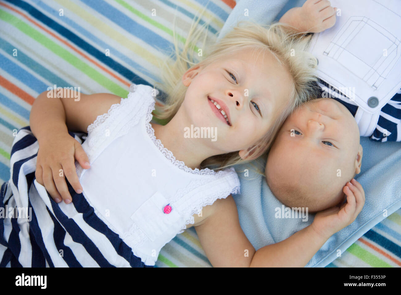 Carino Sorellina posa accanto al suo fratellino sulla coperta. Foto Stock