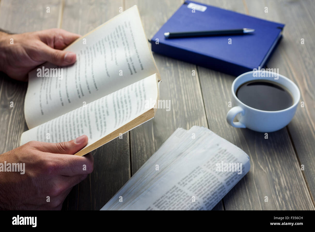 Persona libro di lettura alla scrivania Foto Stock