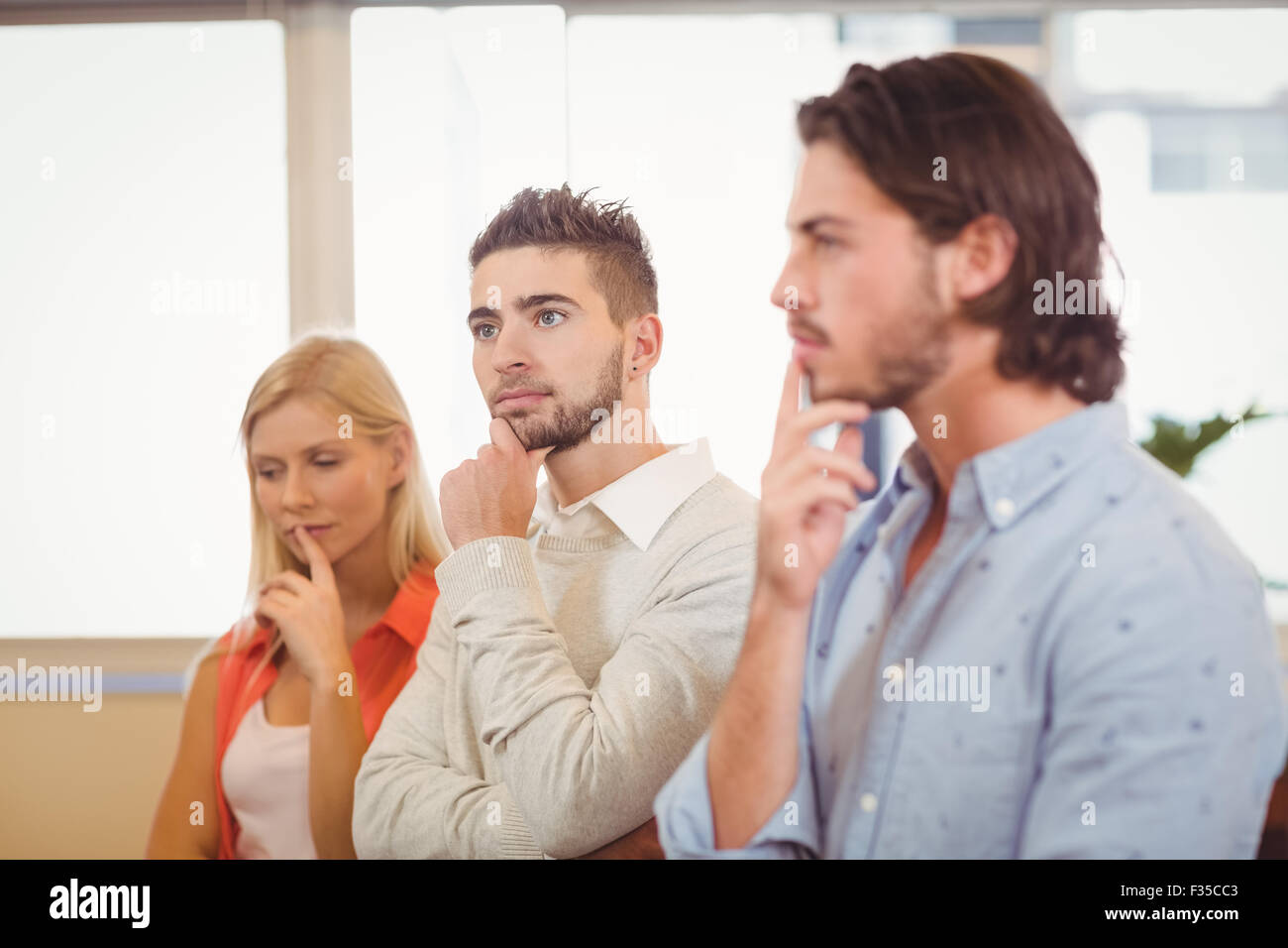 Considerato la gente di affari con la mano sul mento Foto Stock