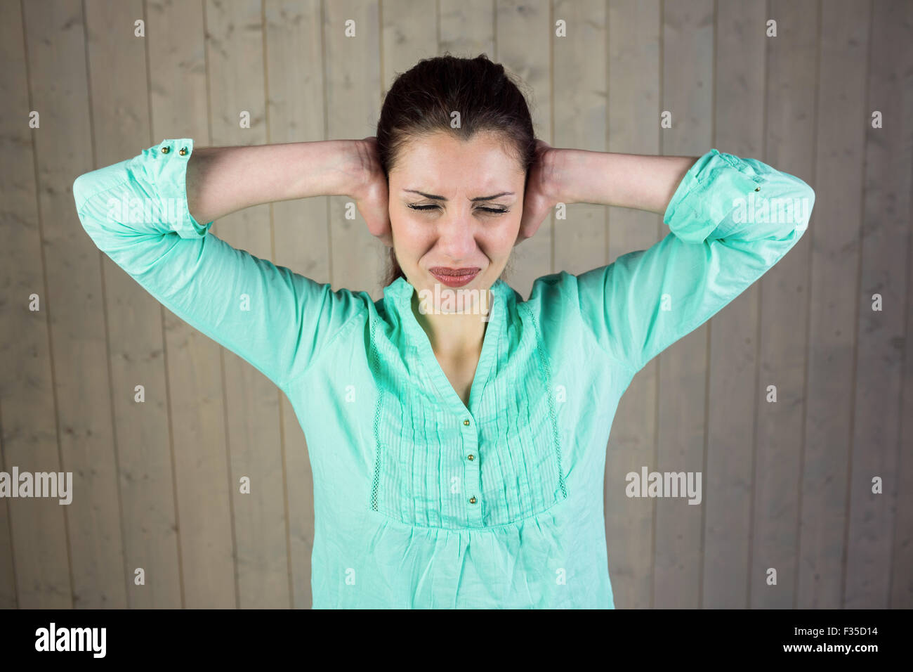 Donna che copre le orecchie e gli occhi chiusi Foto Stock