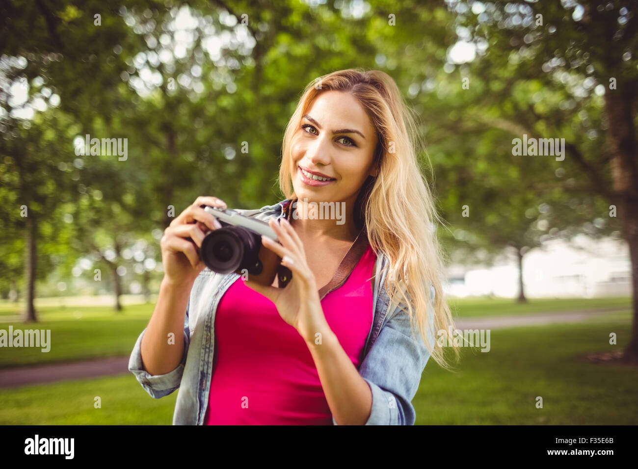 Donna sorridente tenere la fotocamera Foto Stock