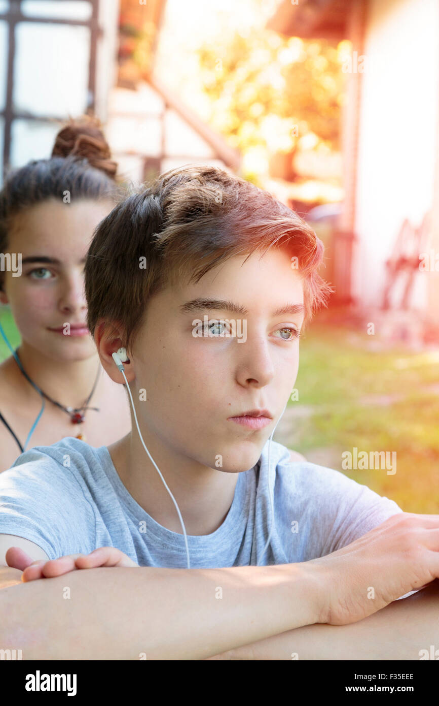 Ragazzo adolescente ascolta musica, una seconda dietro di lui Foto Stock