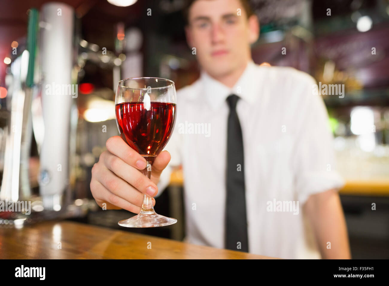 Barista maschio che serve bevande alcoliche Foto Stock