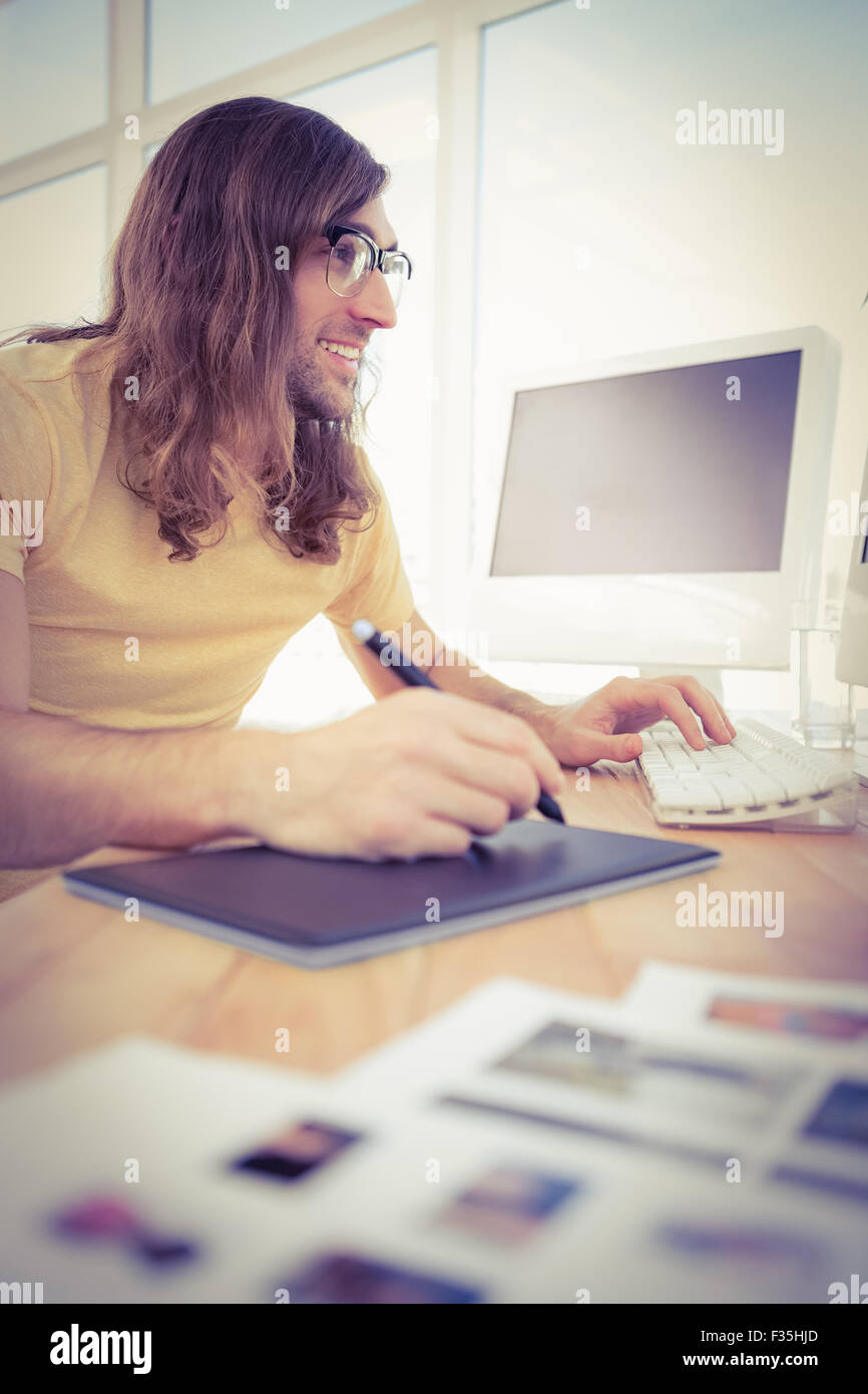 Hipster con tavoletta grafica digitando sulla tastiera Foto Stock