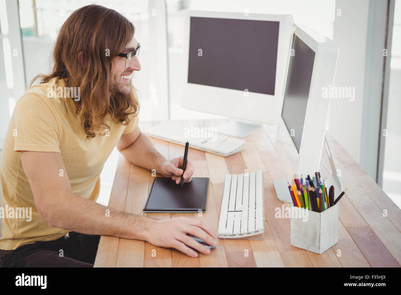 Felice hipster con tavoletta grafica guardare il computer Foto Stock