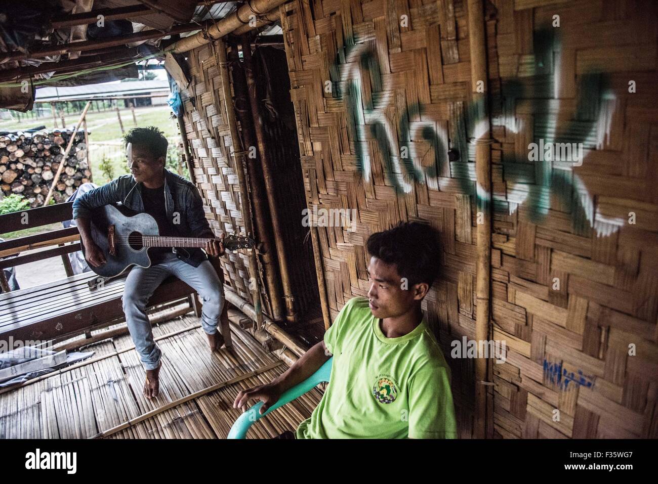 Un rifugiato kachin suona la chitarra in un campo di rifugiati in stato Kachin, Myanmar Foto Stock