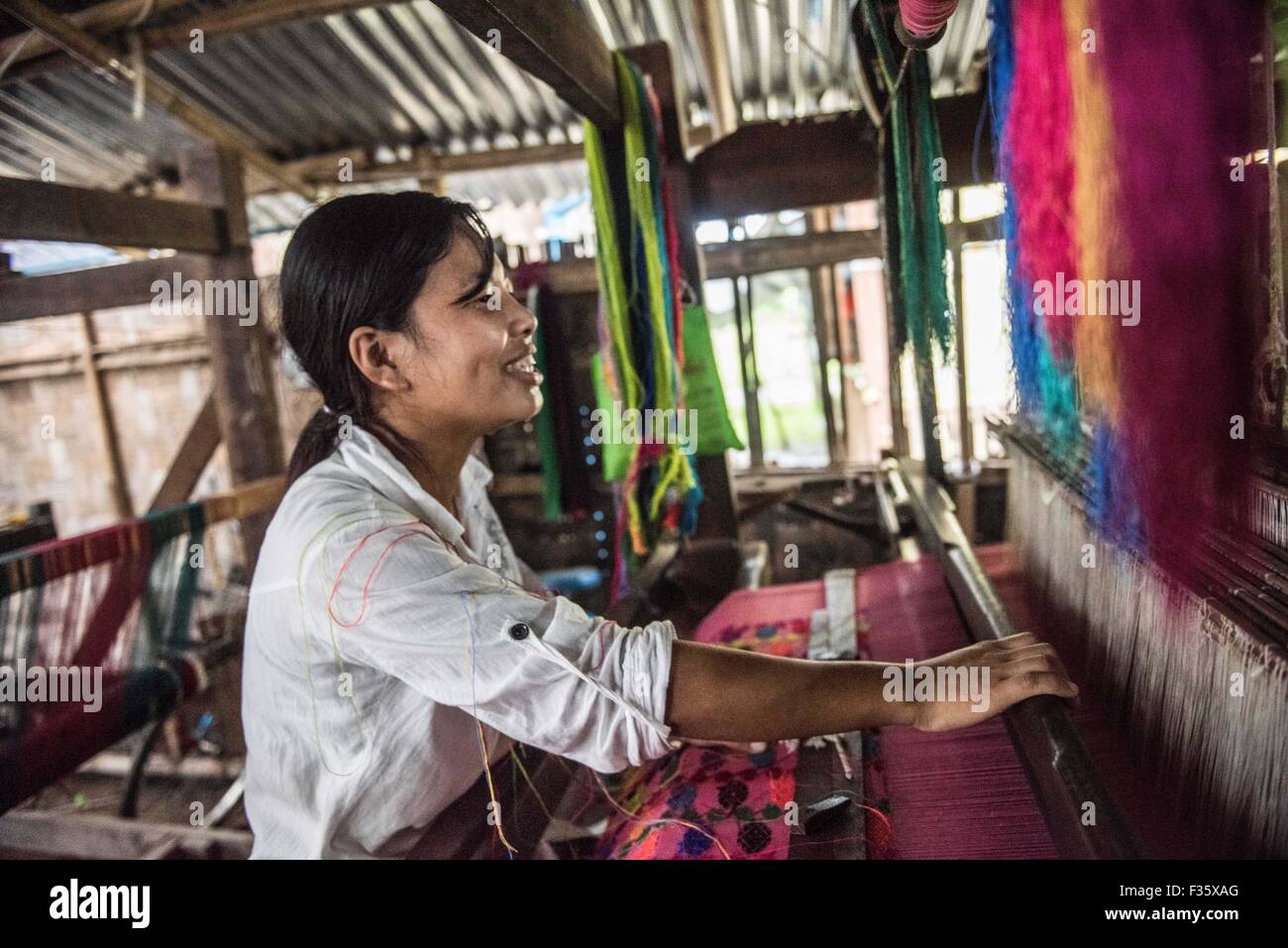 Una donna che lavora in un telaio di tessitura in Stato Kachin, Myanmar Foto Stock