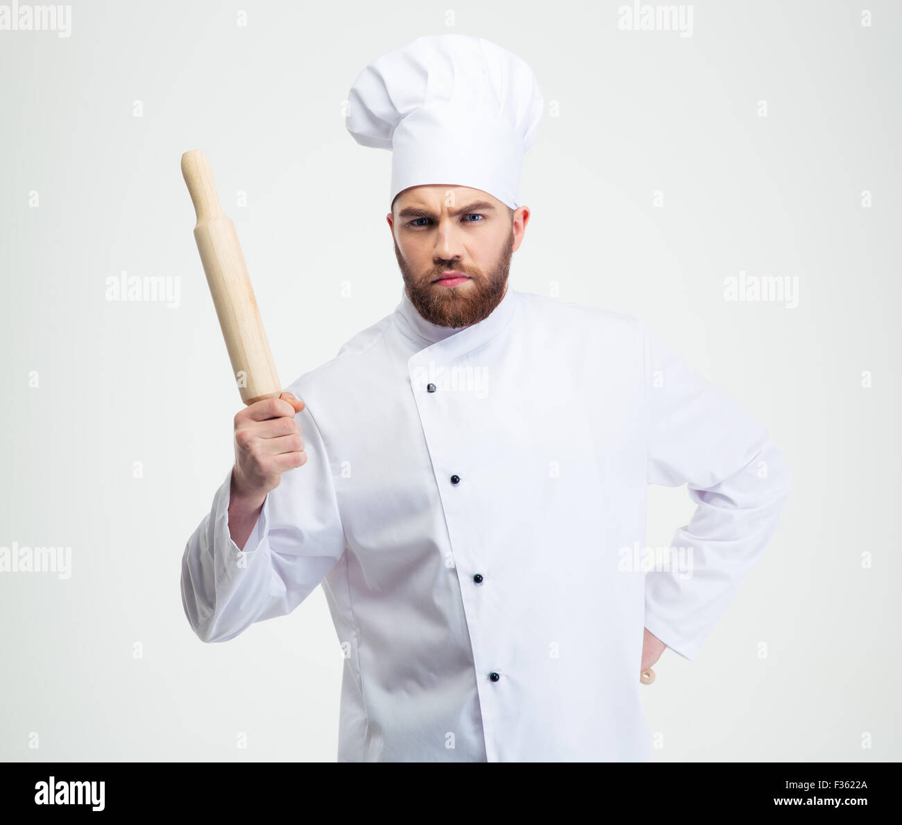 Ritratto di un maschio serio chef cucinare tenendo un matterello isolato su uno sfondo bianco Foto Stock