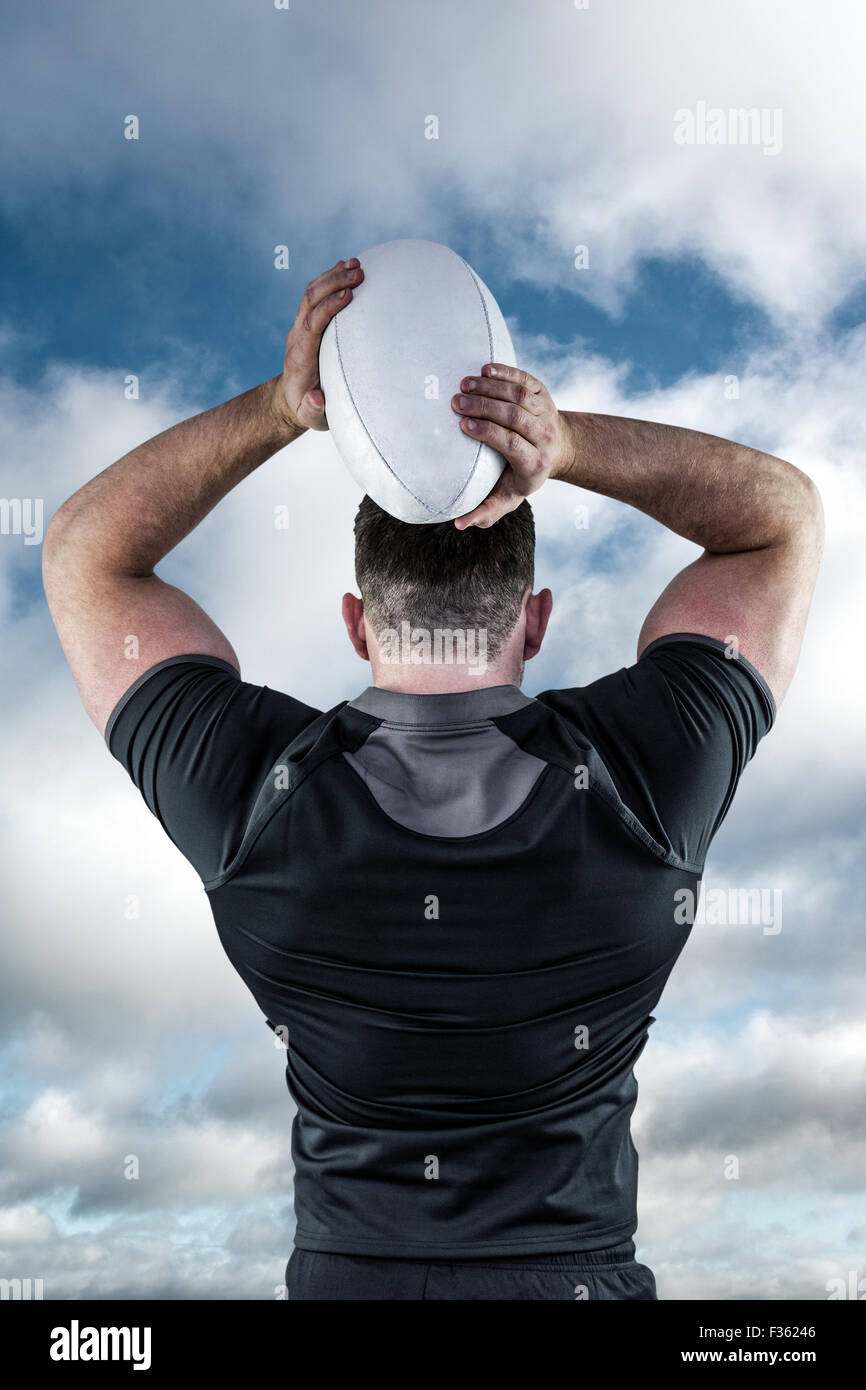 Immagine composita di duro giocatore di rugby gettando la sfera Foto Stock