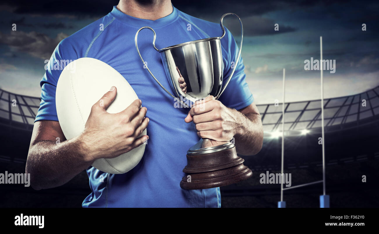 Immagine composita del giocatore di rugby trofeo holding e la sfera Foto Stock