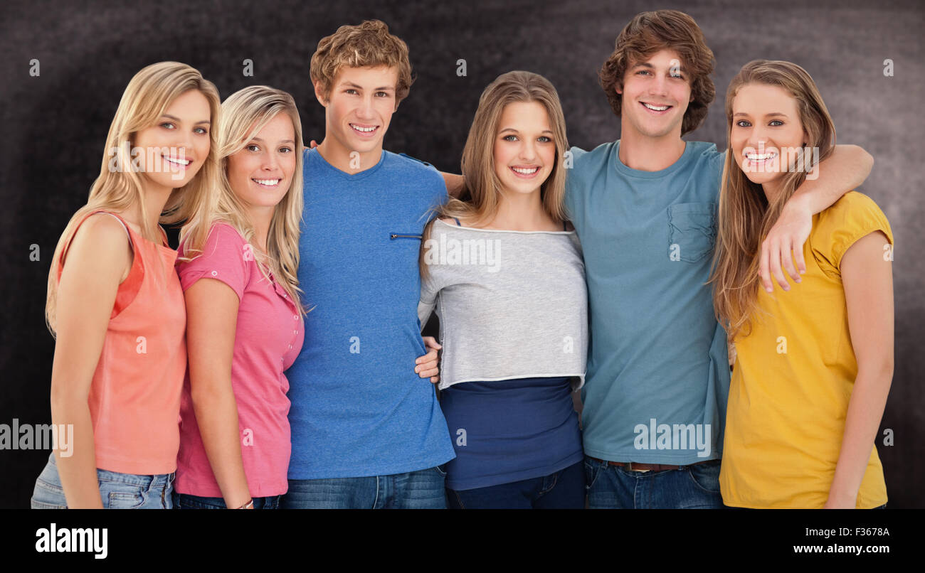 Immagine composita di un gruppo di amici sorridente e la tenuta di ciascun altro Foto Stock