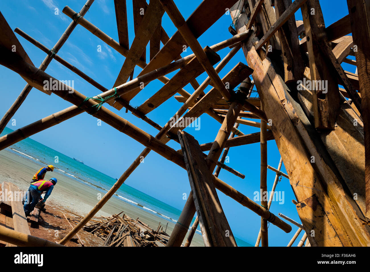 Costruzione navale ecuadoriana lavoratori costruire un tradizionale in legno nave da pesca in un cantiere artigianale a Manta, Ecuador. Foto Stock