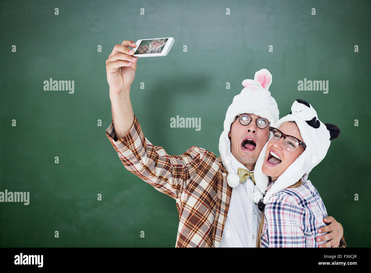 Immagine composita di geeky hipster giovane tenendo selfie con smart phone Foto Stock