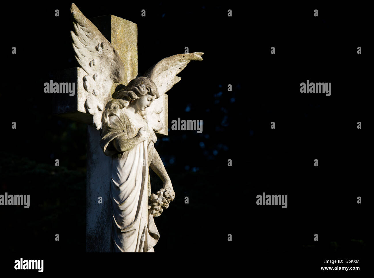 Angelo croce di pietra tombale nella luce solare. In Inghilterra. Foto Stock