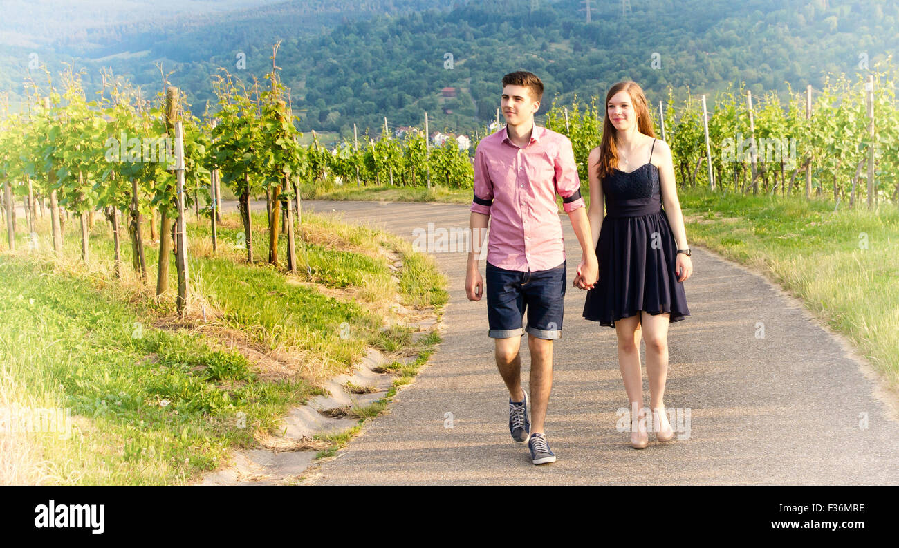 Coppia giovane a camminare su una strada in un vigneto Foto Stock