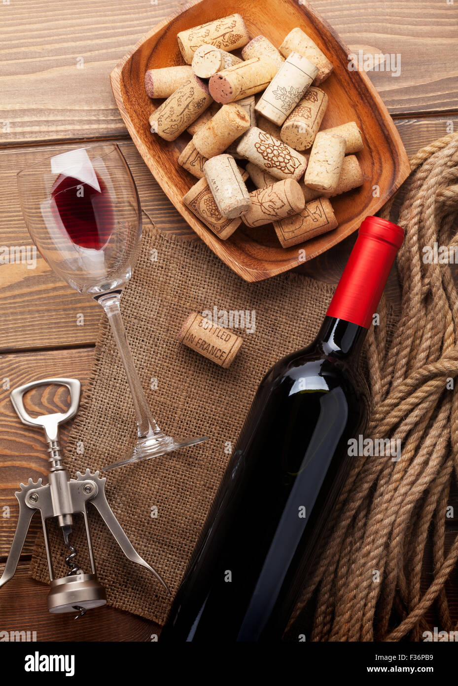 Vino rosso bottiglia, bicchiere di vino, ciotola con tappi di sughero e un  cavatappi. Vista da sopra su tavola in legno rustico sfondo Foto stock -  Alamy