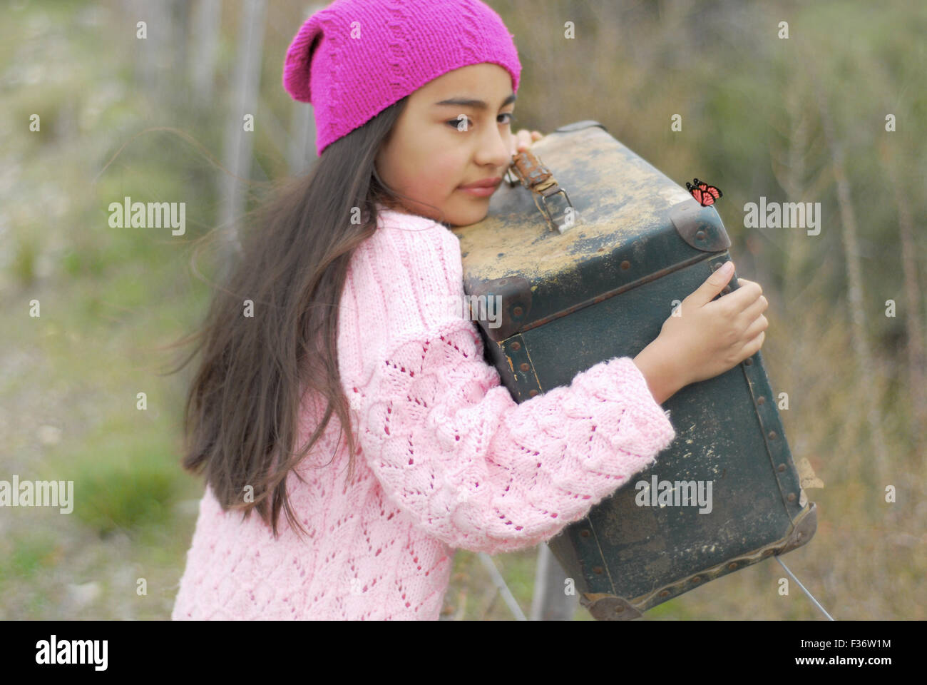 Bambina con una vecchia borsa home escape Foto Stock