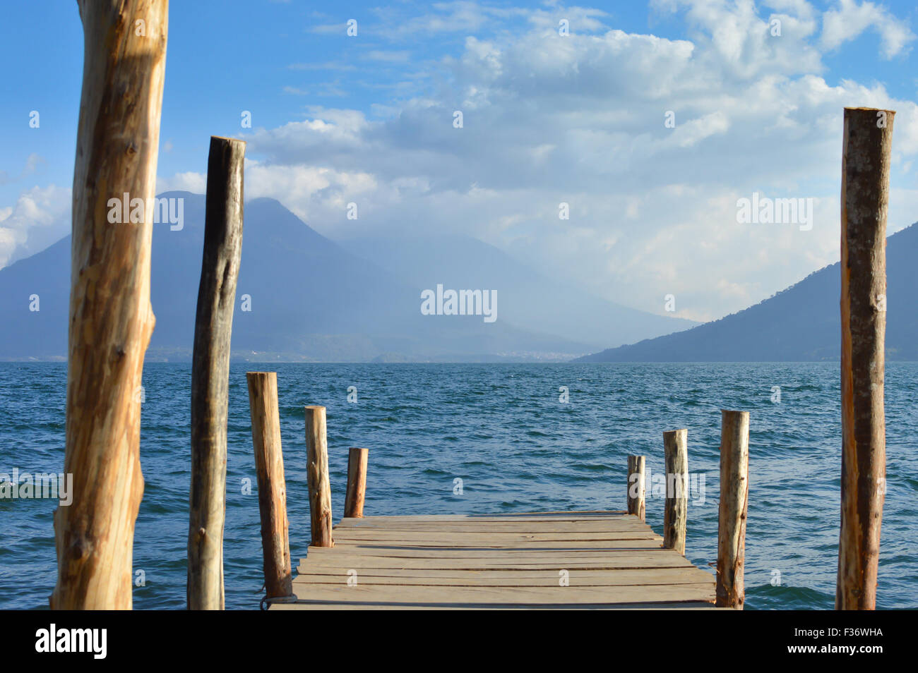 Barca dock presso un piccolo villaggio di San Marcos sul lago Atitlan in Guatemala con i vulcani sullo sfondo Foto Stock