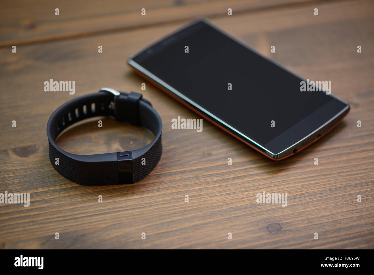 Dispositivo indossabile, wirst watch tipo Sport Tracker e smart phone su una tavola di legno Foto Stock