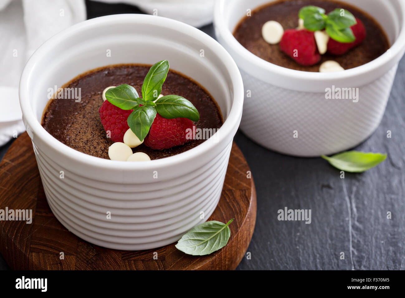Pentole di cioccolato de creme dessert in ramekins con lamponi Foto Stock