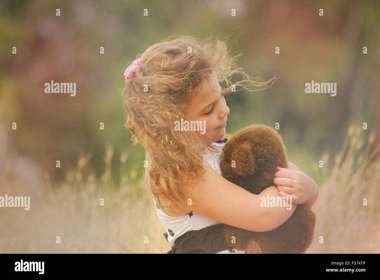 Bambina che abbraccia il suo orsacchiotto Foto Stock