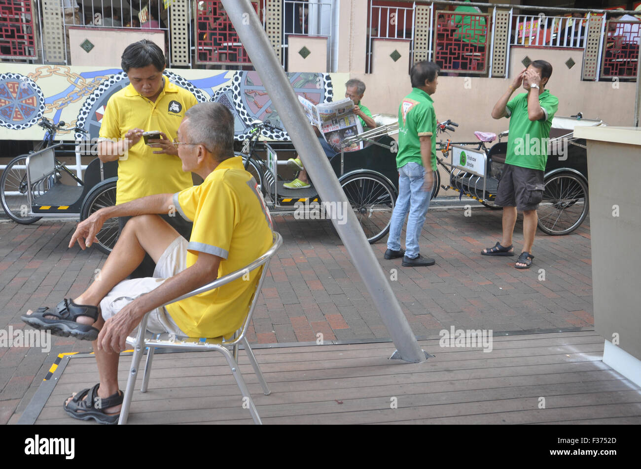 Singapore. Pedicab driver hanno parlare mentre si attende per il passeggero. Foto Stock