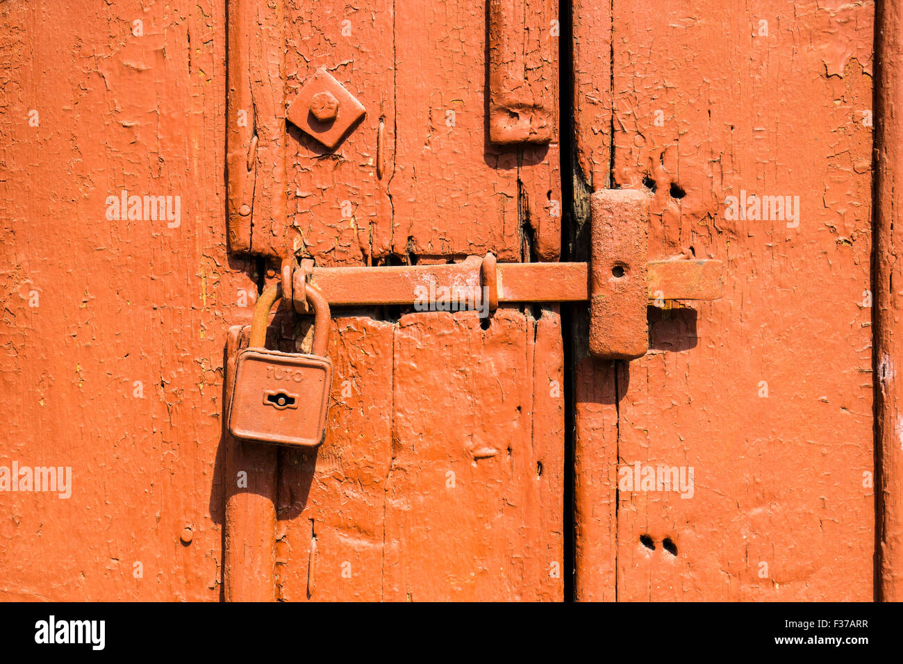 Vecchia dipinta porta arancione con un catenaccio, Ungheria Foto Stock