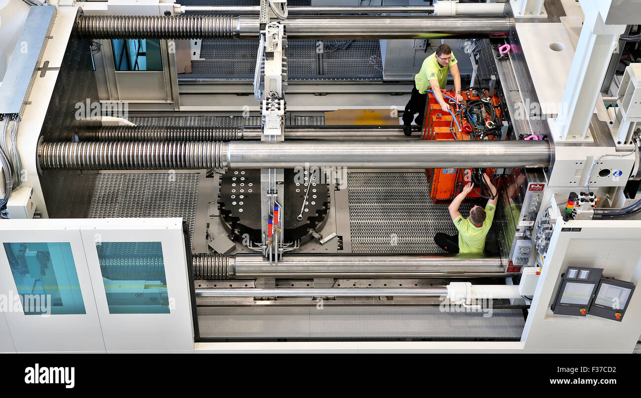 Il tecnico Sven Storck (anteriore) e Mario Porges dotare il motore di fusione che viene immesso nel tedesco iniziativa federale cluster di eccellenza per le strutture di leggero a TU di Chemnitz. Il recente sviluppo multi-componente di macchina può combinare diverse materie plastiche in un processo di stampaggio ad iniezione. Questa leggera, altamente stabile il veicolo può funzionare sia con cappucci di plastica o metallo materiali di base. Un totale di 30 milioni di euro sono stati investiti nel complesso: la macchina ammonta a 3,257 metri quadrati e 25 metri di lunghezza, di peso di 200 ton. Foto:. Foto: Jan Woitas/dpa Foto Stock